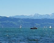 See mit Schiff und Bergen im Hintergrund