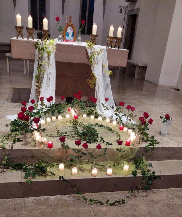 Kerzen und Rosen vor dem Altar im Chorraum der Pfarrkirche in Grünkraut