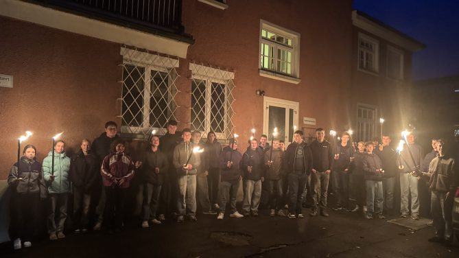 auf dem Bild sind die Firmbewerber mit Fackeln zu sehen