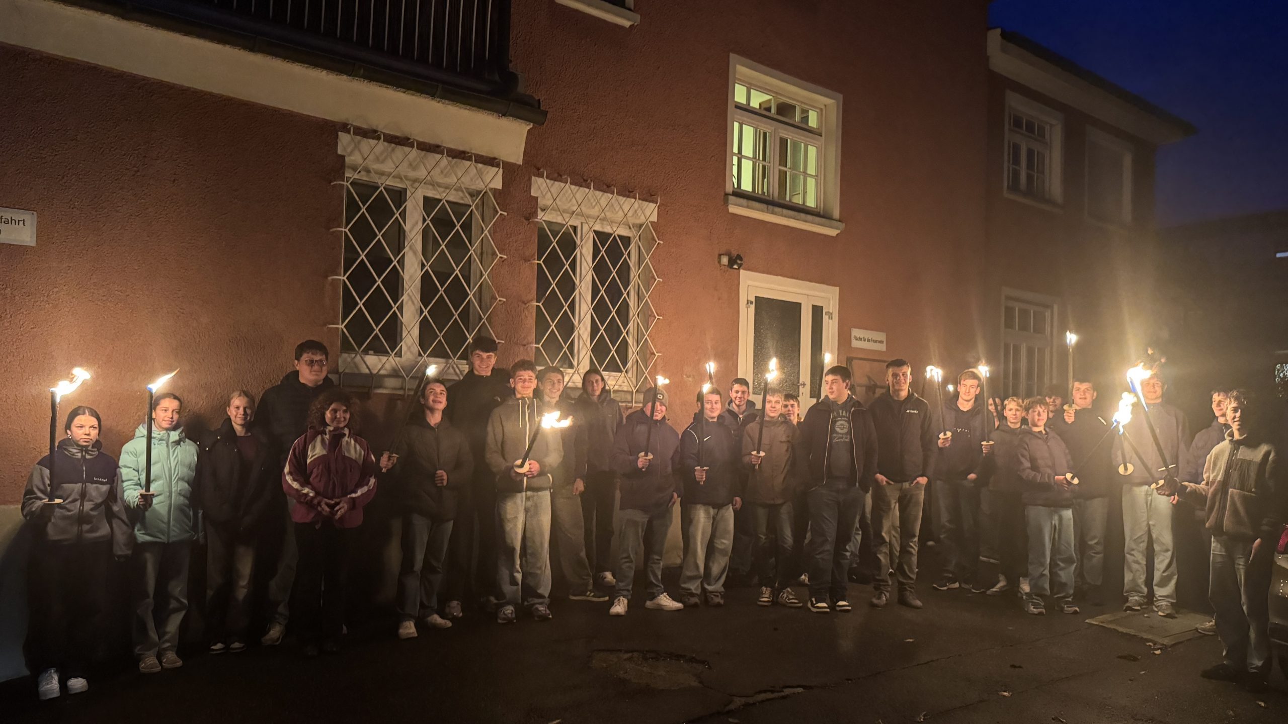 auf dem Bild sind die Firmbewerber mit Fackeln zu sehen